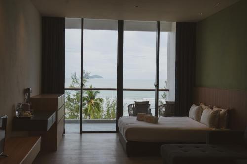 ein Hotelzimmer mit einem Bett und einem großen Fenster in der Unterkunft Roxy Beach Apartment in Sematan