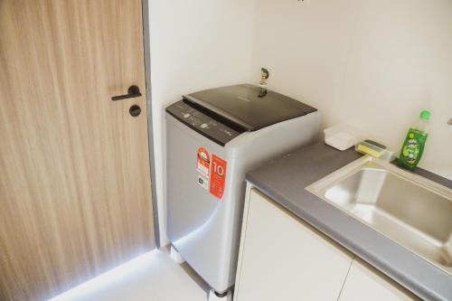 a small kitchen with a sink and a refrigerator at Roxy Beach Apartment in Sematan