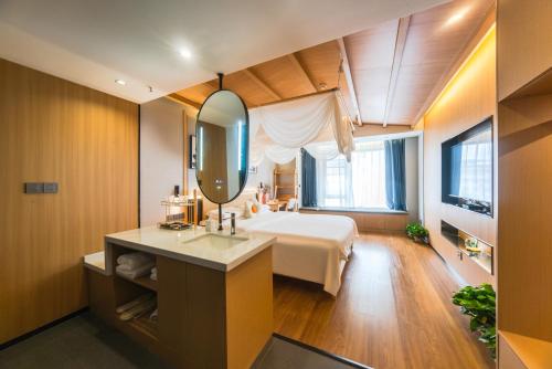 a bedroom with a bed and a mirror at AT NIGHT HOTEL Chengdu in Chengdu