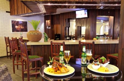 a restaurant with two tables with food and drinks at Cresta Sprayview Victoria Falls in Victoria Falls