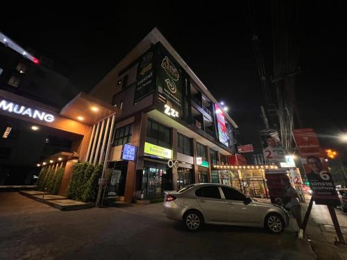 um carro estacionado em frente a um edifício à noite em Peony's Home em Ban Don Muang (1)