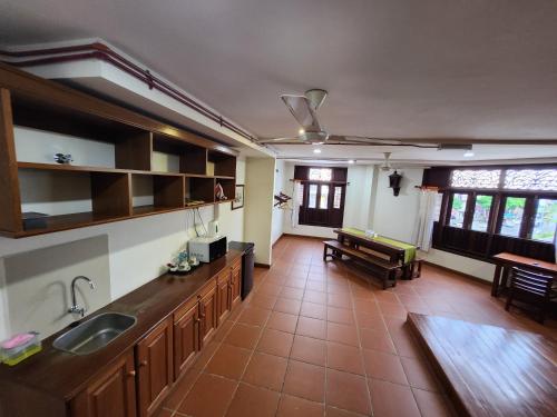 a kitchen with a sink and a living room at Uptown Eco Hotel in Kuala Terengganu