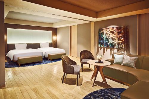 a bedroom with a bed and a table and a couch at ANA InterContinental Appi Kogen Resort by IHG in Hachimantai