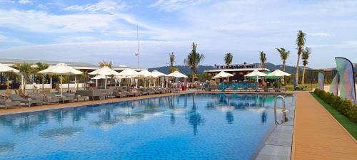 a swimming pool with chairs and umbrellas at a hotel at Summer Bay Beach Club & Cabins in Sihanoukville