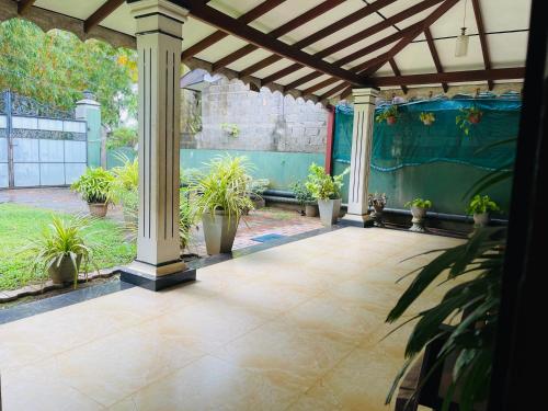a patio with potted plants and a pergola at Shalomi's villa & Happy Home in Negombo