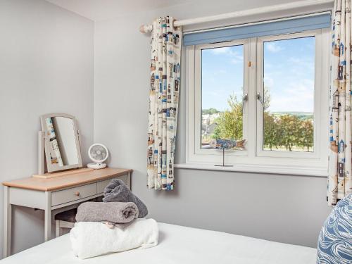 a bedroom with a window and a bed and a desk at 6 Camelside in Wadebridge