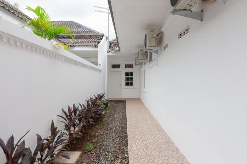 a hallway of a house with white walls and plants at Urbanview Hotel De Breeze Kemang Jakarta by RedDoorz in Jakarta