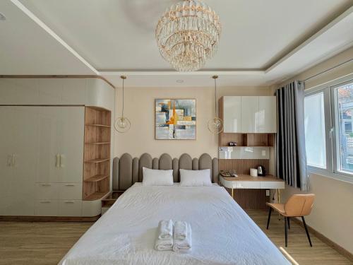um quarto com uma cama grande e um lustre em Amazing Merit Ben Thanh em Ho Chi Minh