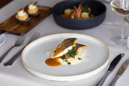 a white plate with food on a table at Hotel Du Lac Congress Center & Spa in Ioannina