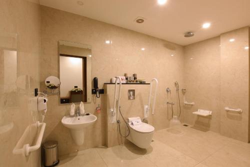 a bathroom with a shower toilet and a sink at HOTEL PRINCE in Kāladi