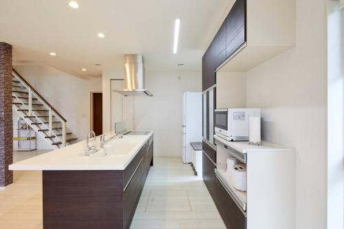 a kitchen with a sink and a microwave at The Garden Villa 九十九里ー遊び充実の海近リゾート別荘を最大15名で一棟貸切 in Shirako