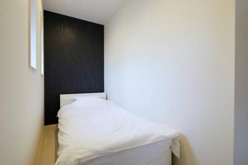a white bed in a corner of a room at The Garden Villa 九十九里ー遊び充実の海近リゾート別荘を最大15名で一棟貸切 in Shirako