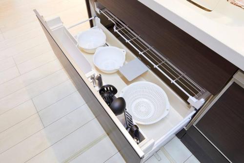 an open dishwasher with dishes and a fan in a kitchen at The Garden Villa 九十九里｜BBQ＆露天風呂＆ドッグラン in Shirako