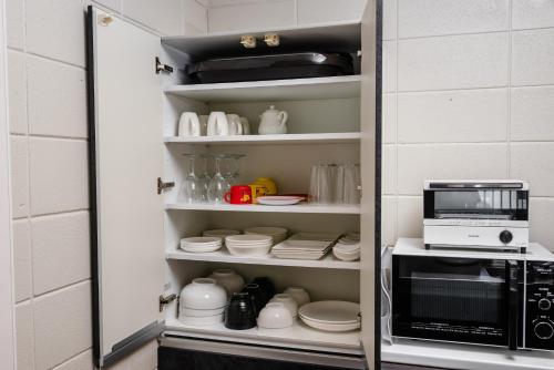 a cupboard filled with dishes and a microwave at LEGO in Uruma