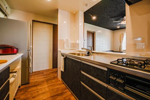 a large kitchen with a sink and a stove at LEGO in Uruma