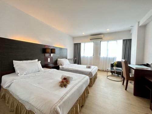 コタキナバルにあるParadise Suite at SCSP, Jalan Ming gardenのベッド2台と机があるホテルの部屋