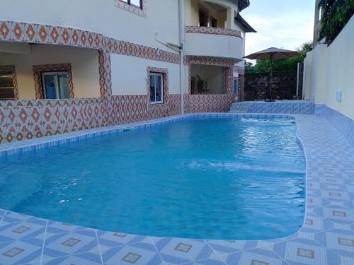 a swimming pool in front of a house at Blessing holiday homes - Diani Beach in Diani Beach