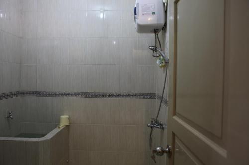 a bathroom with a shower with a sink and a shower at Griya Hanna in Yogyakarta