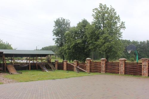 a wooden fence with a playground in a park at Vilkdvaris in Plungė