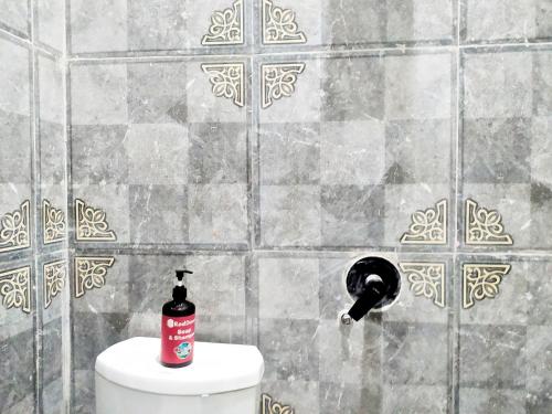 a bathroom with a soap dispenser next to a toilet at RedDoorz Syariah near Exit Tol Bojong Pekalongan in Pekalongan
