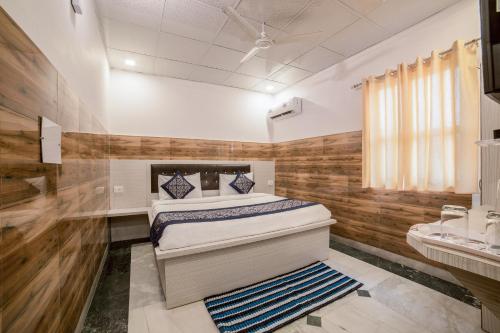 1 dormitorio con 1 cama en una habitación con paredes de madera en Collection O 13772 hotel krishna, en Noida
