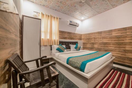 1 dormitorio con 1 cama y pared de madera en Collection O 13772 hotel krishna, en Noida