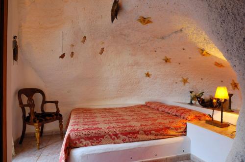 een slaapkamer met een bed, een tafel en een stoel bij Castillo Lanzarote Villa 1 - Sleep in a Volcanic Cave in Tías