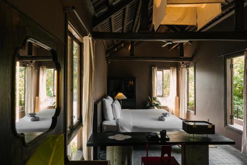 a bedroom with a bed and two windows at TOKI Retreat Vân Long in Ninh Binh