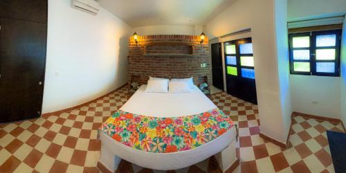a small bedroom with a bed in a room at The Orange House Santa Marta in Santa Marta