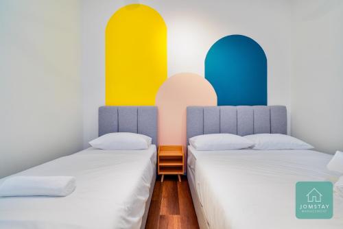 two beds in a room with colorful walls at JOMSTAY Sunway Onsen Suites Ipoh - Lost World of Tambun Ipoh Waterpark in Tambun