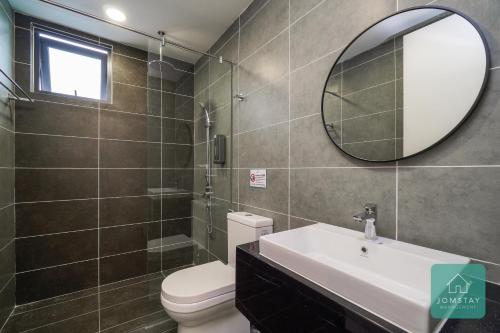 a bathroom with a toilet and a sink and a mirror at JOMSTAY Sunway Onsen Suites Ipoh - Lost World of Tambun Ipoh Waterpark in Tambun