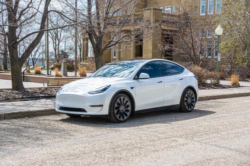 a white tesla car parked on a street at 5 STAR Business Luxury Homeshare in Edmonton