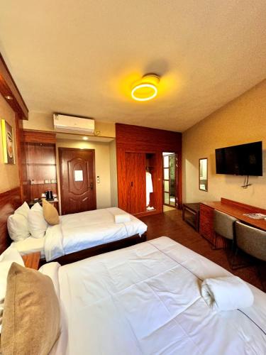 a hotel room with two beds and a flat screen tv at Atmosphere Hotel & Spa in Antananarivo