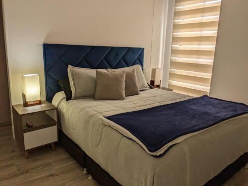 a bedroom with a large bed with a blue headboard at Panorama central in Bogotá