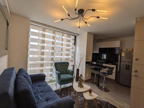 a living room with a blue couch and a kitchen at Panorama central in Bogotá