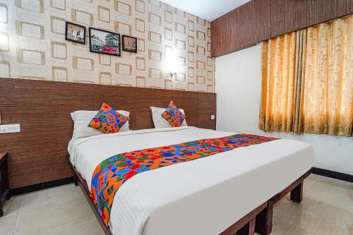 a bedroom with a large bed in a room at FabHotel Shiva Grand in Coimbatore