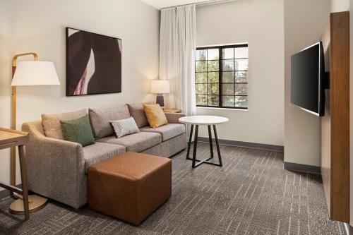 a living room with a couch and a table at Staybridge Suites Minneapolis-Maple Grove by IHG in Maple Grove
