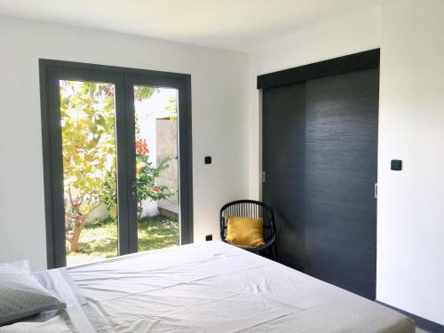 ein Schlafzimmer mit einem Bett und einer Schiebetür in der Unterkunft Villa Paul Ermitage in La Saline-Les-Bains