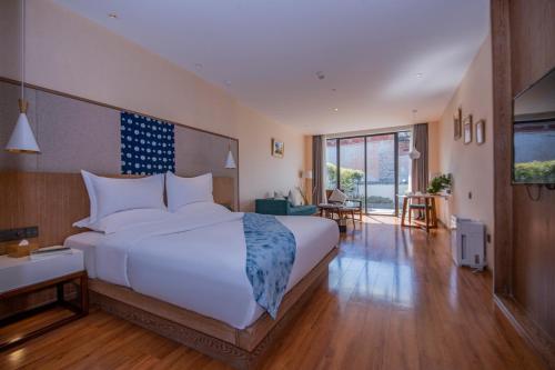 a bedroom with a large bed and a living room at Hong Long Jing Hotel in Dali