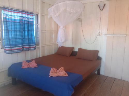 a bed in a room with two bows on it at Happiness Guesthouse in Koh Rong Sanloem