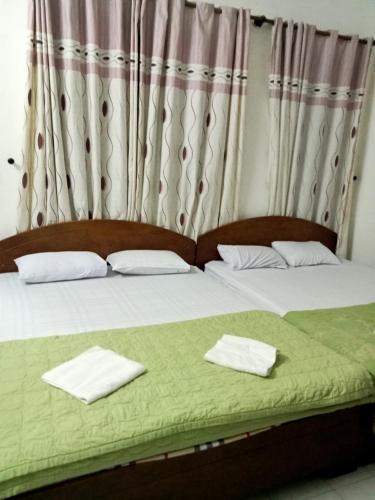 ein Schlafzimmer mit 2 Betten und Handtüchern darauf in der Unterkunft Nhà nghỉ MINH HOÀNG in Vũng Tàu
