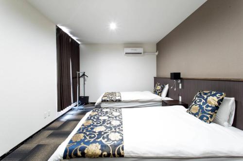 1 dormitorio con 2 camas y ventana en ホリディパールホテル, en Osaka