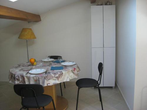 une table à manger avec des chaises et un tissu de table dans l'établissement T 2 avec velux sous les combes de 34 m2, à La Londe-les-Maures