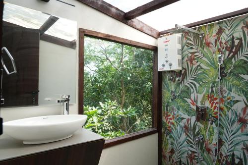 a bathroom with a sink and a window at SaffronStays Aranya Vilas & Raanwaara Cottage in Āmbavna