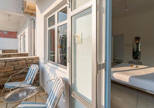 a room with two chairs and a bed on a balcony at Moustache Udaipur Verandah in Udaipur