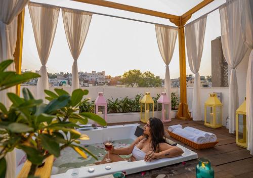 a woman sitting in a bath tub on a balcony at Moustache Udaipur Verandah in Udaipur