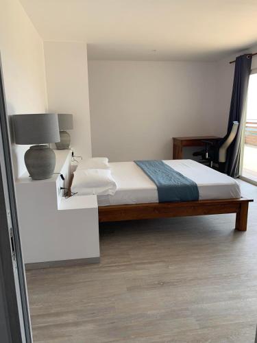 a bedroom with a bed and a lamp and a window at Puunui Lodge in Vairao