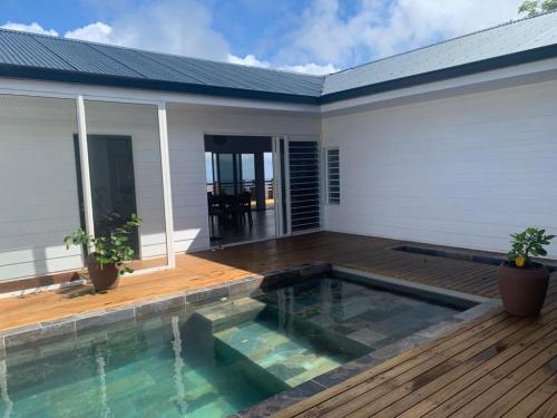 a swimming pool in front of a house at Puunui Lodge in Vairao