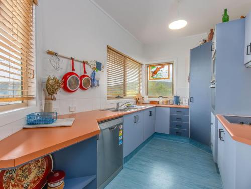 a kitchen with blue and white cabinets and blue floors at Hastings Cove Holiday Apartments in Hastings Point