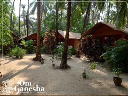 a resort with palm trees and a building at Om Ganesha in Palolem